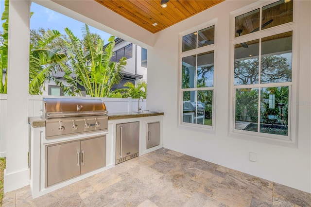 view of patio / terrace featuring an outdoor kitchen, area for grilling, and a sink