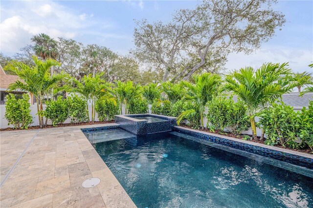 view of swimming pool featuring a patio, fence private yard, and a pool with connected hot tub