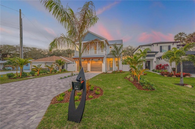 view of front facade with decorative driveway, an attached garage, and a lawn