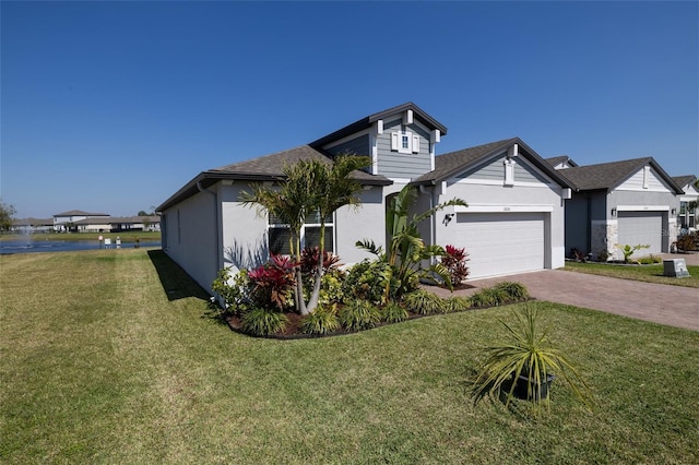 view of front of home featuring a garage, stucco siding, decorative driveway, and a front yard