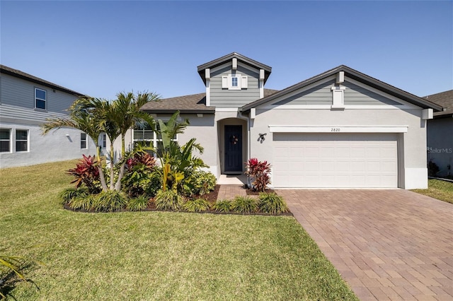 view of front of home with a garage, a front lawn, decorative driveway, and stucco siding