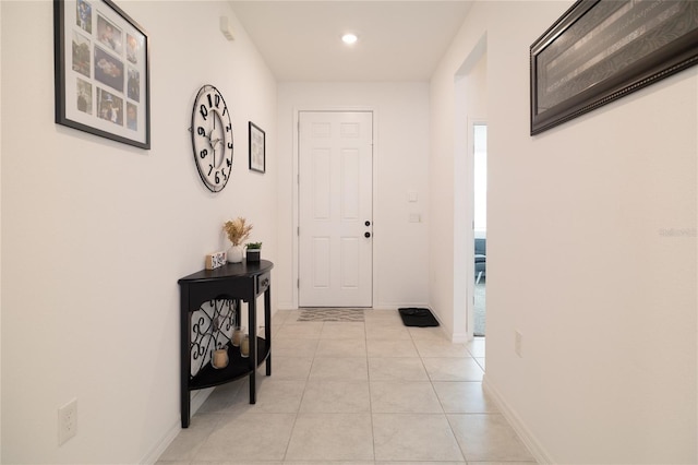 corridor featuring light tile patterned floors, baseboards, and recessed lighting