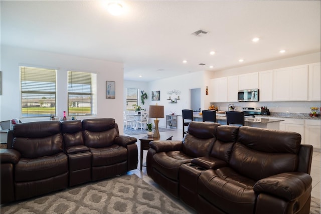 living room featuring light tile patterned floors, visible vents, and recessed lighting