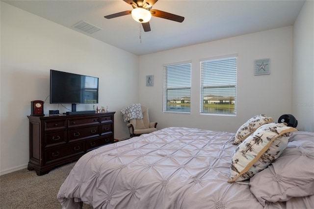 carpeted bedroom with baseboards, visible vents, and a ceiling fan