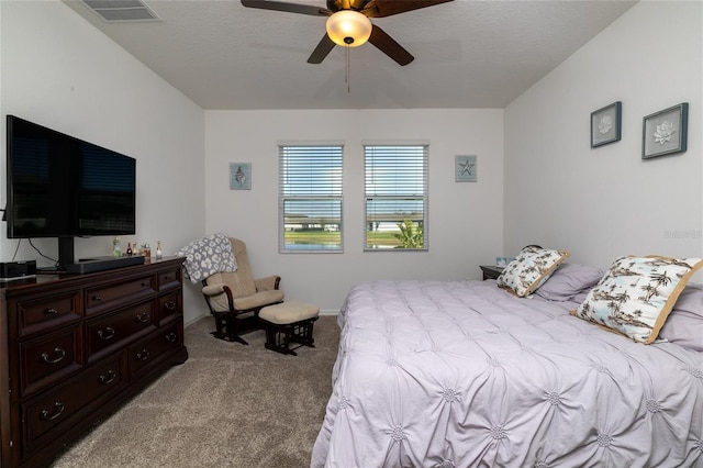 bedroom with a ceiling fan, light colored carpet, visible vents, and a textured ceiling