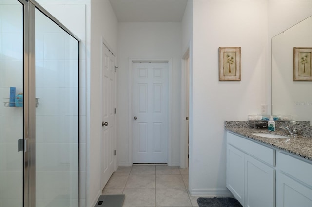 full bath featuring baseboards, a shower stall, vanity, and tile patterned floors