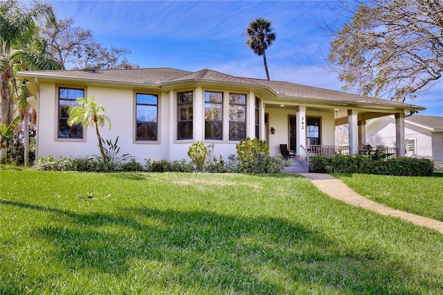 ranch-style home featuring a porch, a front yard, and stucco siding