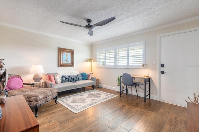 living room featuring a ceiling fan, ornamental molding, a textured ceiling, and wood finished floors