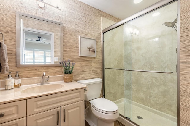 bathroom featuring toilet, a shower stall, and vanity