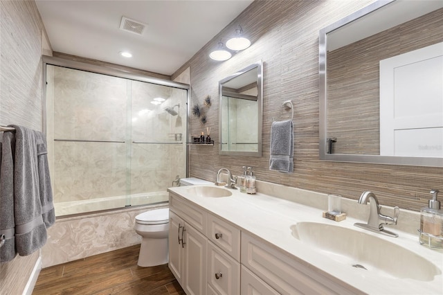 bathroom with toilet, a sink, visible vents, and tile walls