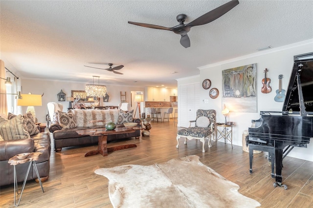 living room featuring crown molding, wood finished floors, and ceiling fan with notable chandelier