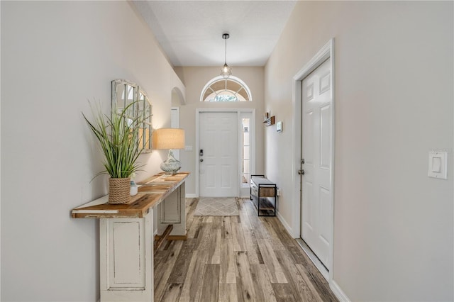 entryway featuring baseboards and light wood finished floors