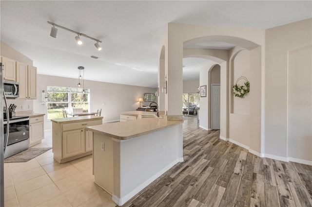 kitchen featuring stainless steel appliances, light countertops, visible vents, cream cabinets, and a sink