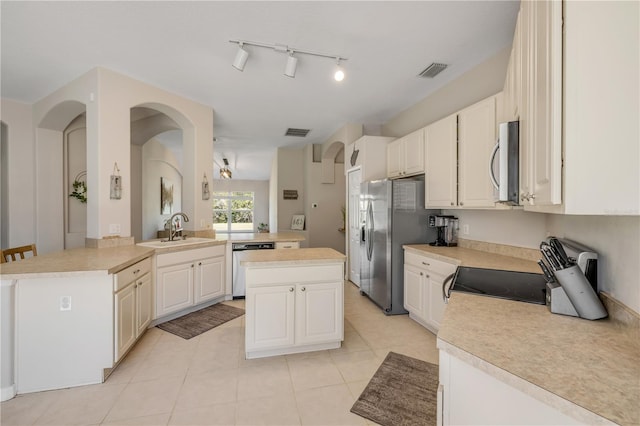 kitchen with stainless steel appliances, light countertops, visible vents, and a sink