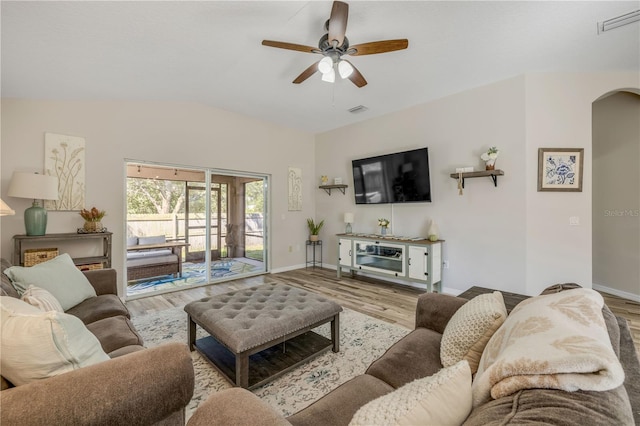 living room featuring visible vents, arched walkways, and wood finished floors