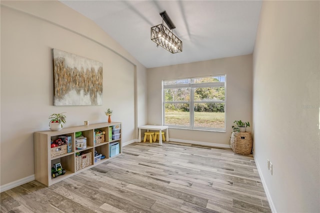 sitting room featuring lofted ceiling, wood finished floors, and baseboards