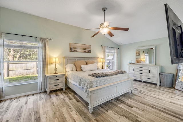 bedroom with vaulted ceiling, ceiling fan, and light wood-style floors