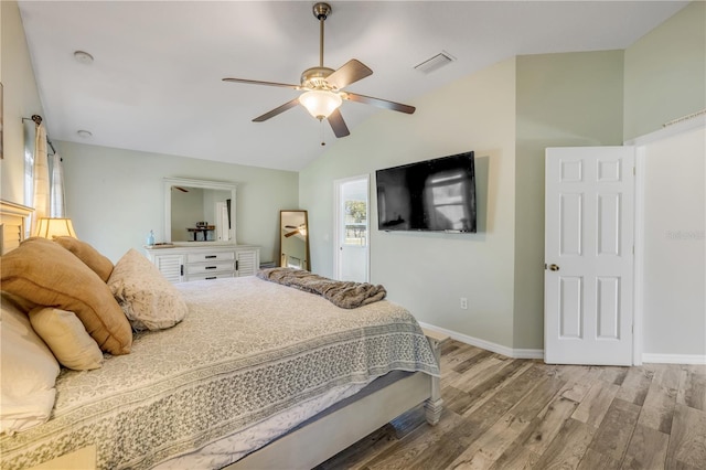 bedroom with vaulted ceiling, wood finished floors, visible vents, and baseboards