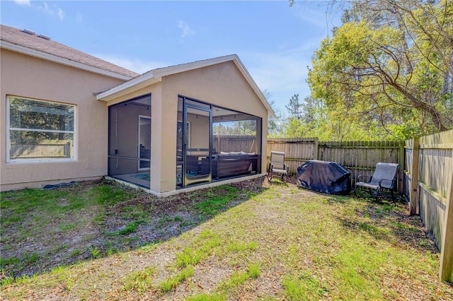 view of yard featuring a sunroom and a fenced backyard