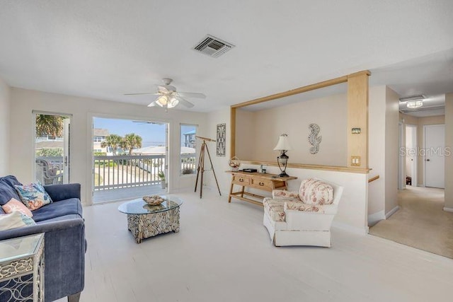 living room featuring a ceiling fan and visible vents