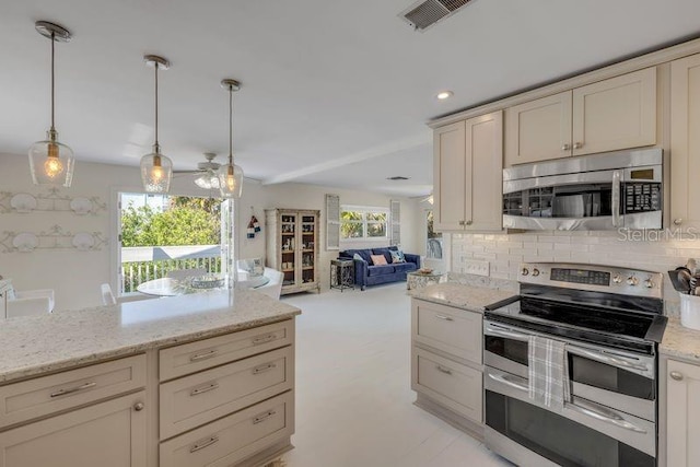 kitchen featuring tasteful backsplash, visible vents, appliances with stainless steel finishes, open floor plan, and cream cabinetry