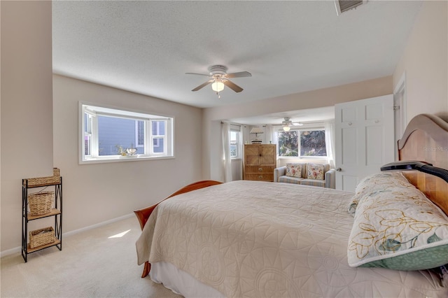 bedroom featuring a textured ceiling, carpet floors, a ceiling fan, visible vents, and baseboards