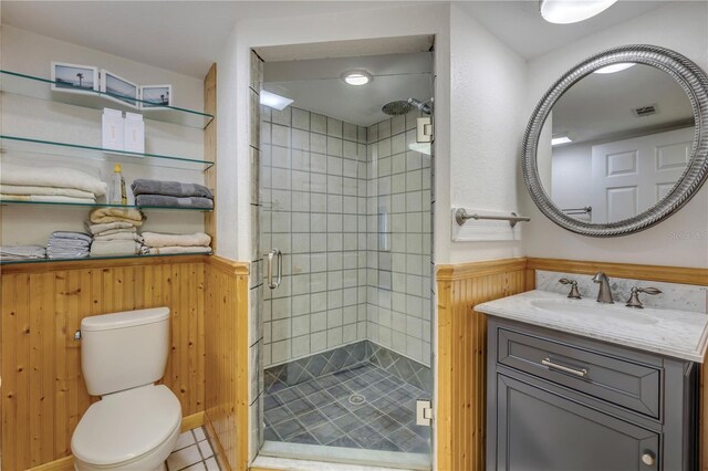 full bath with toilet, a wainscoted wall, visible vents, vanity, and a stall shower