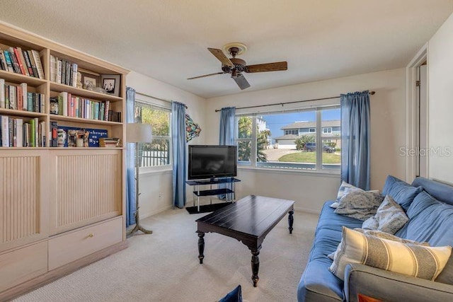 carpeted living area featuring a ceiling fan