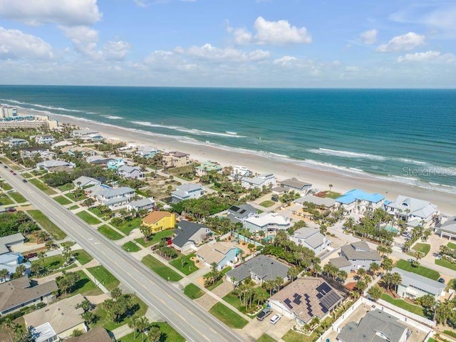 birds eye view of property featuring a water view and a beach view