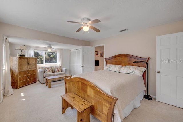 bedroom featuring ceiling fan, visible vents, a closet, and light colored carpet