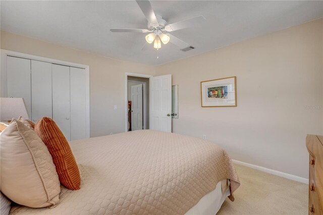 bedroom with ceiling fan, light carpet, visible vents, baseboards, and a closet