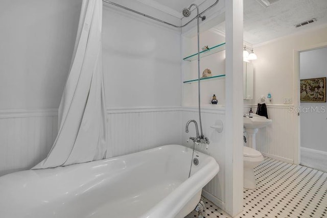 bathroom featuring visible vents, wainscoting, toilet, a textured ceiling, and a freestanding bath