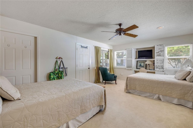 bedroom featuring carpet floors, ceiling fan, and a textured ceiling