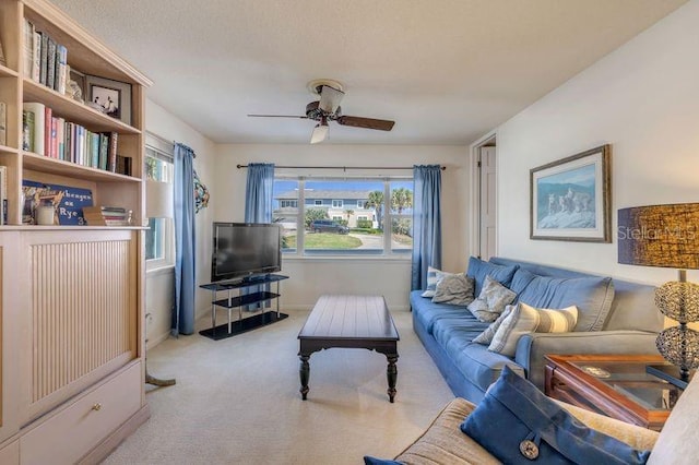 carpeted living area featuring a ceiling fan