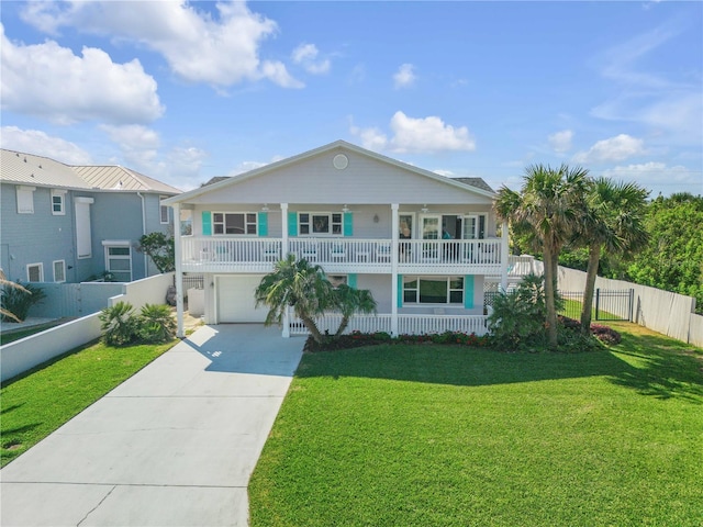 view of front facade with driveway, a porch, a front yard, and fence