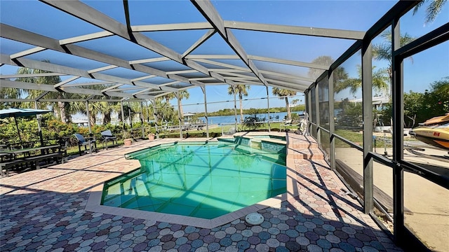 view of pool with a lanai, a water view, a pool with connected hot tub, and a patio