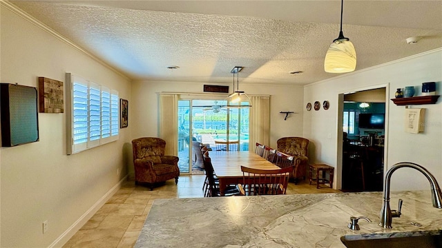 dining room featuring a textured ceiling, baseboards, and crown molding