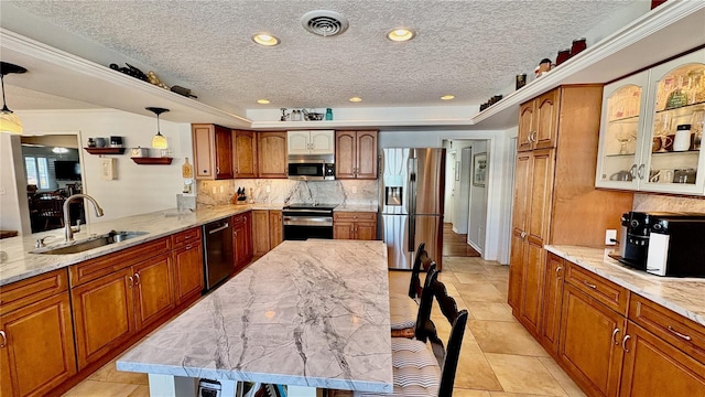 kitchen with appliances with stainless steel finishes, a sink, visible vents, and brown cabinets