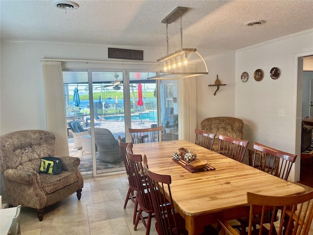 dining room with a textured ceiling, ornamental molding, and visible vents