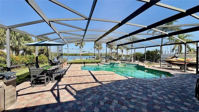 view of pool with a patio, a pool with connected hot tub, a water view, and glass enclosure