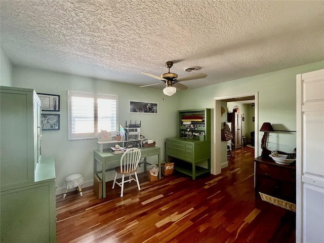 office area featuring baseboards, visible vents, dark wood finished floors, a ceiling fan, and a textured ceiling