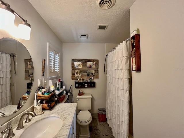 bathroom with visible vents, a textured ceiling, and vanity