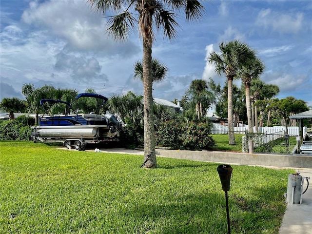 view of home's community featuring a lawn and fence