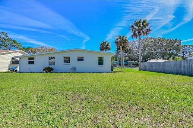 back of house featuring a yard and fence