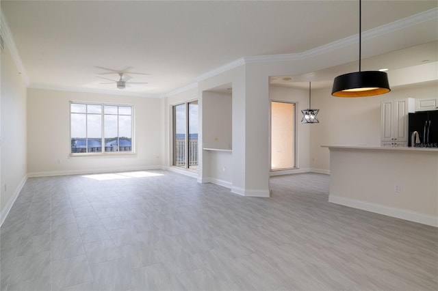 unfurnished living room with ceiling fan, ornamental molding, and baseboards