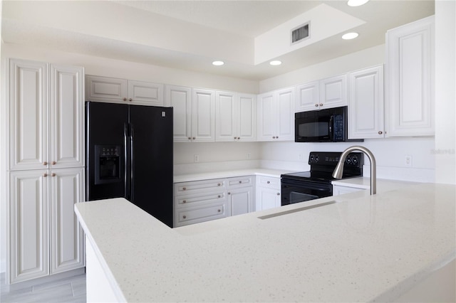 kitchen with recessed lighting, black appliances, and light stone countertops