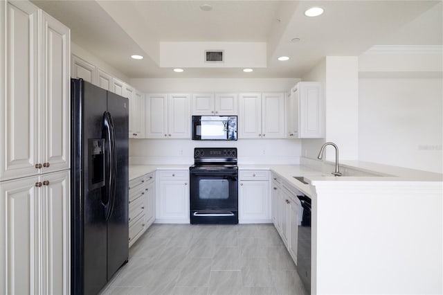 kitchen with a peninsula, a sink, visible vents, black appliances, and a raised ceiling