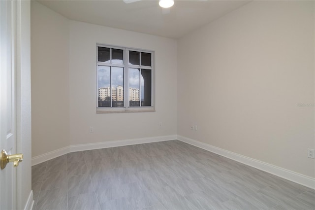 spare room with ceiling fan and baseboards