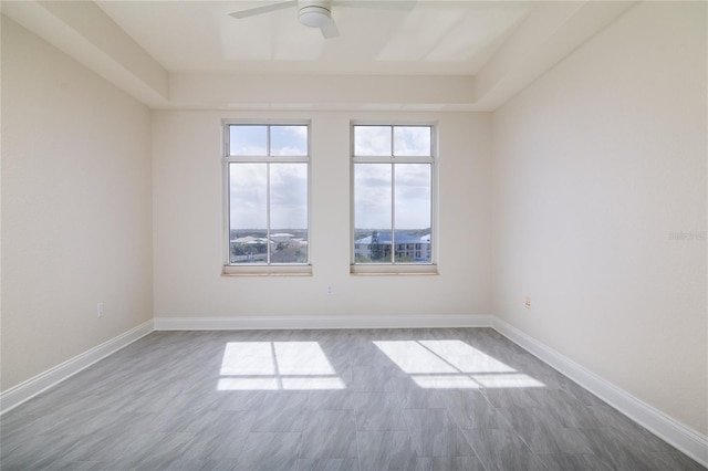 unfurnished room with ceiling fan and baseboards