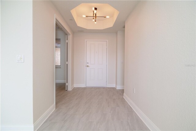 265 Minorca Beach Way Unit 505, New Smyrna Beach, FL 32169 - corridor with a tray ceiling, a chandelier, and baseboards
